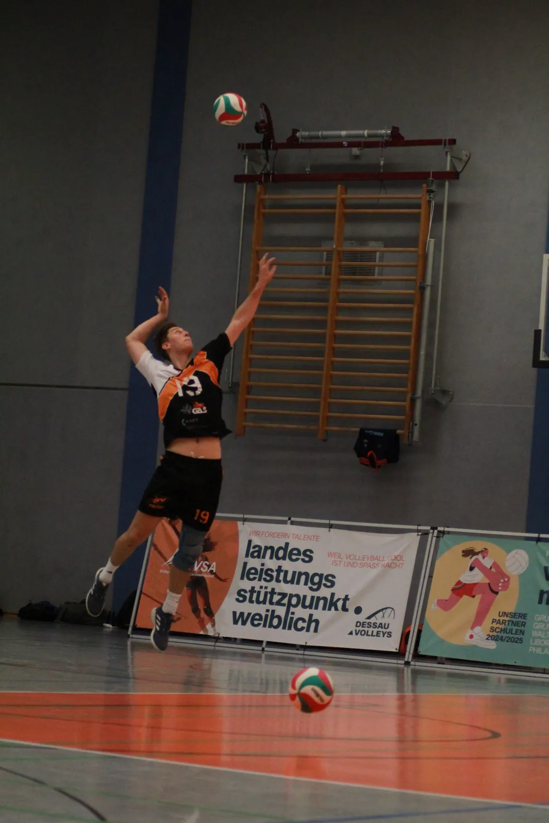 Spieler beim Aufschlag, der Ball steigt hoch