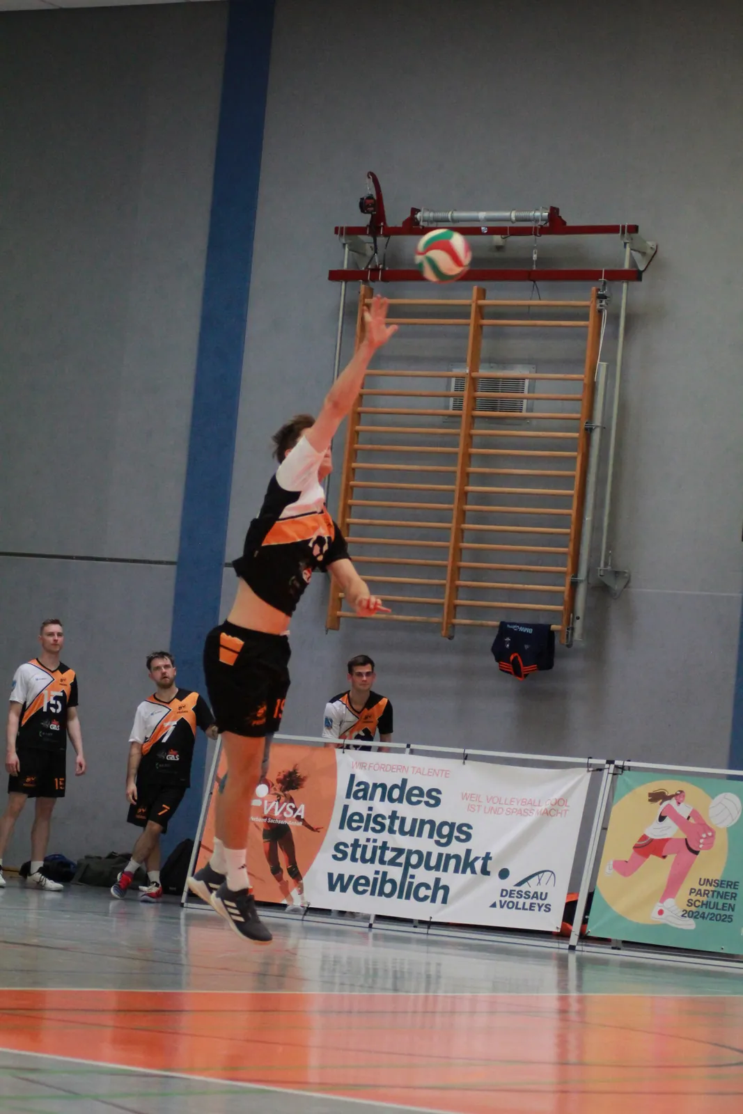 Aufschlag vor der Sprossenwand in der Sporthalle