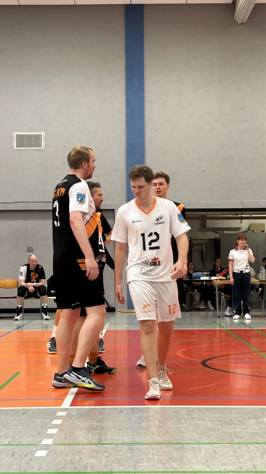 Zwei Volleyballspieler stehen im Gespraech am Spielfeldrand